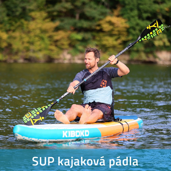 Muž sedící na paddlebordu, pádlující oboustranným SUP kajakovým pádlem